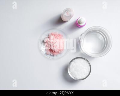 Crème de soins de beauté, sérum, sel rose himalayan, cire microcristalline et alcool. Produits chimiques pour soins de beauté sur table de laboratoire blanche. (Vue de dessus) Banque D'Images