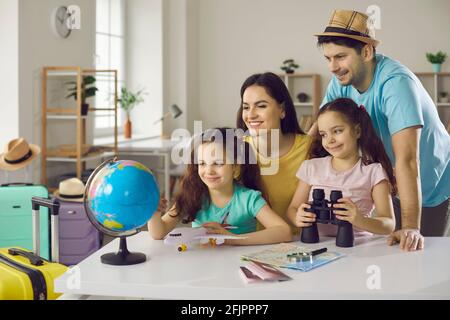 Une famille gaie et active souriant et regardant le monde entier en vue d'un nouveau voyage de vacances. Banque D'Images