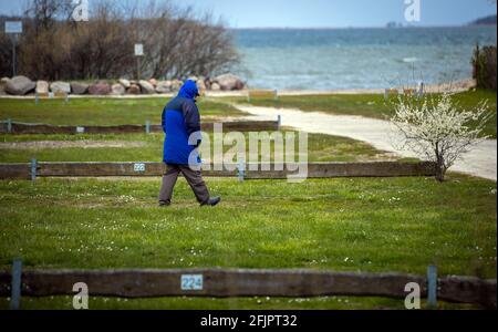 Pepelow, Allemagne. 22 avril 2021. Un homme marche sur les emplacements vides pour des caravanes ou des tentes sur le terrain d'Ostseecamping 'Am Salzhaff'. En raison des mesures de protection de Corona, les campings de Mecklembourg-Poméranie-Occidentale sont actuellement fermés, même les campeurs permanents ne sont pas autorisés à passer la nuit dans leurs caravanes ou tentes. Credit: Jens Büttner/dpa-Zentralbild/dpa/Alay Live News Banque D'Images