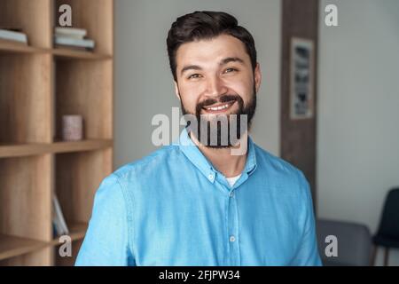 Souriant homme caucasien millénaire pigiste dans le portrait de tête de bureau Banque D'Images