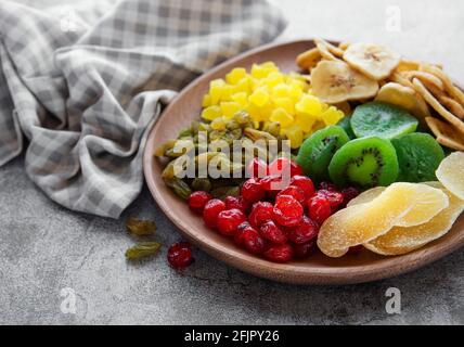 Bol avec divers fruits séchés sur fond de béton gris Banque D'Images