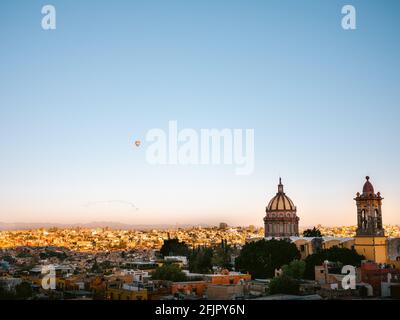 Ballons d'air chaud au-dessus de la ville de San Miguel de Allende, Mexique autour du lever du soleil. Photo de voyage colorée. Banque D'Images