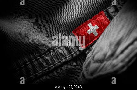 Étiquette sur les vêtements foncés sous la forme du drapeau De la Suisse Banque D'Images