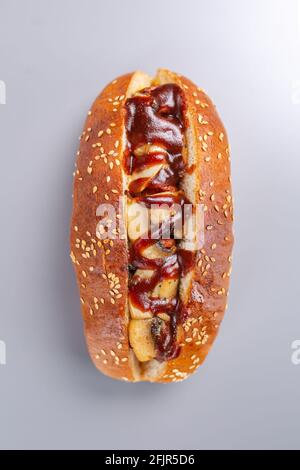 hot dog avec ketchup et champignons. Sur une table grise Banque D'Images