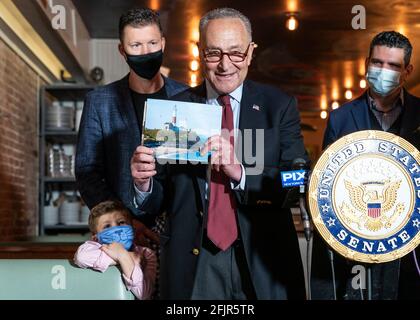 New York, États-Unis. 25 avril 2021. Le leader de la majorité au Sénat Charles Schumer a annoncé à Crave Fishbar que les travaux pour protéger le phare historique de Montauk point débuteront en mai 2021. Le sénateur siad a dit que l'argent fédéral sera disponible pour que le corps des ingénieurs de l'Armée protège le phare pour qu'il glisse dans l'océan. Le sénateur tient dans ses mains l'image du phare. Le phare a été construit en 1796 sous le projet propulsé par George Washington. (Photo de Lev Radin/Pacific Press) crédit: Pacific Press Media production Corp./Alay Live News Banque D'Images