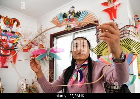 (210426) -- JINAN, 26 avril 2021 (Xinhua) -- Yang Hongwei fait le squelette d'un cerf-volant dans le village de Yangjiabu, ville de Weifang, dans la province de Shandong, en Chine orientale, 16 avril 2021. Yang Hongwei, née dans une famille de kites à Yangjiabu, s'est lancée dans son voyage de fabrication de kites en 1982 sous la direction de son grand-père. Au cours des 40 années suivantes, Yang a développé l'héritage culturel et a gagné ses œuvres de nombreuses distinctions. En tant que maître kite-making, elle a également été invitée dans d'autres pays, dont l'Allemagne, l'Australie, les États-Unis et la Nouvelle-Zélande, pour promouvoir la culture kite et le tr Banque D'Images