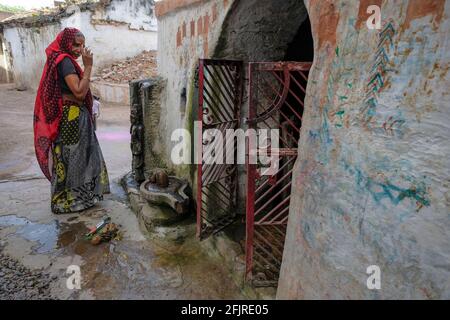 Khajuraho, Inde - Mars 2021: Une femme faisant une offrande à l'extérieur d'un petit temple hindou à Khajuraho le 31 mars 2021 à Madhya Pradesh, Inde. Banque D'Images