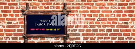 Tableau de bienvenue de la fête du travail sur fond de mur de briques. Concept de la Journée internationale des travailleurs. Banque D'Images