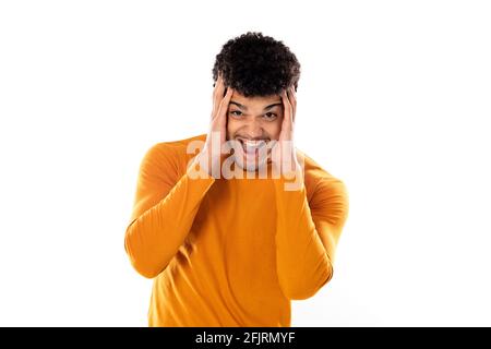 Mignon africain américain avec une coiffure afro portant une orange T-shirt isolé sur fond blanc Banque D'Images