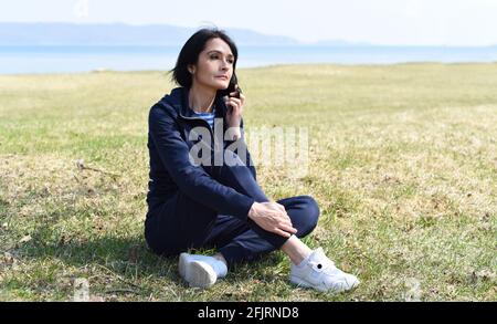 45 ans Femme russe assise et appréciant la nature à la plage de la mer japonaise. Banque D'Images