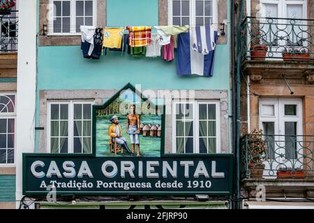 Façade traditionnelle du magasin : 'Casa Oriental' avec vêtements de blanchisserie dans un balcon Banque D'Images