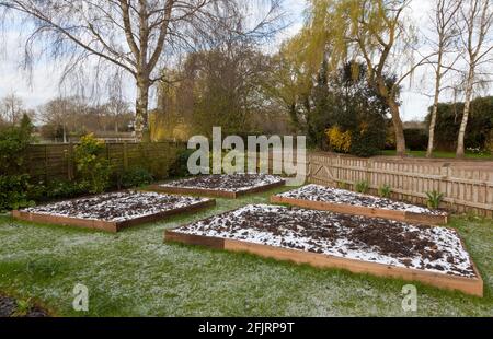 Nouveaux lits surélevés de jardin recouverts d'une épaisse couche de neige Banque D'Images