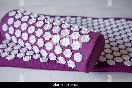 Tapis de massage en gros plan avec coussin et conseils de massage blancs, tapis de massage pour la détente et le traitement. Banque D'Images