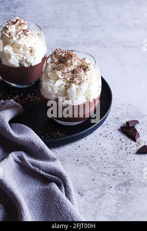 Deux tasses de pudding au chocolat liegeois nappées de crème fouettée et de chocolat râpé. Banque D'Images