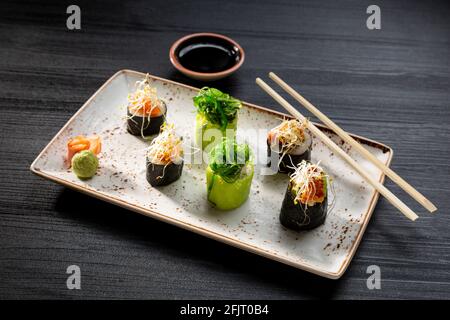 gros plan sur un assortiment de petits pains à sushis sur fond sombre, cuisine typiquement japonaise. Banque D'Images