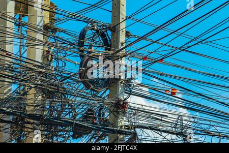 Chaos absolu de câble sur la colonne de puissance thaïlandaise à Bangkok Thaïlande avec ciel bleu. Banque D'Images