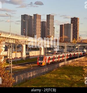 Le train des chemins de fer russes se rend au MCD à l'arrière-plan d'une ville moderne - Moscou, Russie, le 15 octobre 2020 Banque D'Images