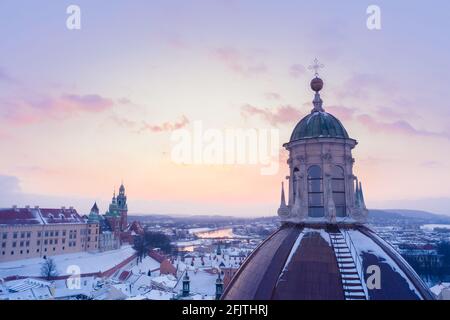 L'hiver à Cracovie, en Pologne, vue aérienne. Dôme de l'église Saints Pierre et Paul et château royal de Wawel avec la Vistule au coucher du soleil. Banque D'Images