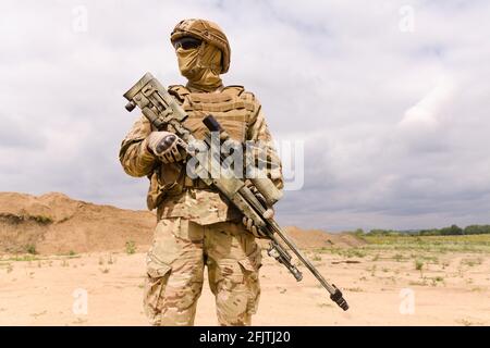 Soldat des forces spéciales entièrement équipé et armé avec fusil de sniper en gros plan. Banque D'Images