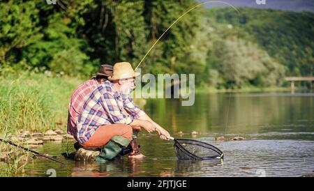 Bonne prise. Hommes barbus pêche. Jour de la famille. Chanceux et qualifiés. Attraper du poisson avec un ami. Les amis pêchent du poisson. Autres pêcheurs. Disques et attachants Banque D'Images