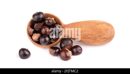 Graines de guarana en cuillère en bois, isolées sur fond blanc. Supplément alimentaire guarana, source de caféine pour boissons énergétiques. Banque D'Images