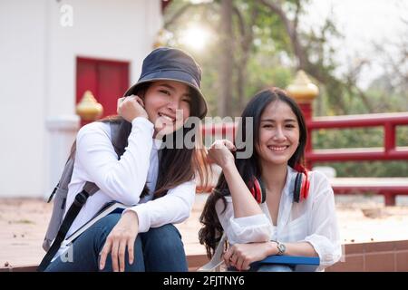 Portrait de deux jeunes asiatiques heureux élèves du secondaire à l'extérieur. Banque D'Images