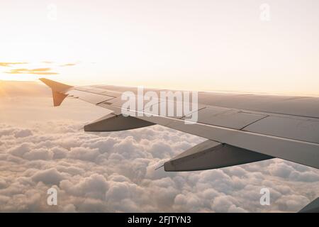 Belle vue du hublot sur l'aile du plan et les nuages sous lui Banque D'Images