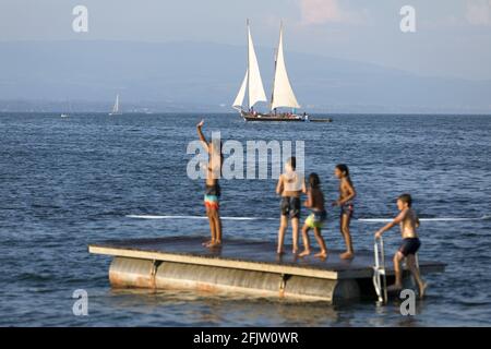 Suisse, Canton de Genève, Genève, Lac Leman, bains des Paquis, Natation et le voilier Neptune en arrière-plan Banque D'Images