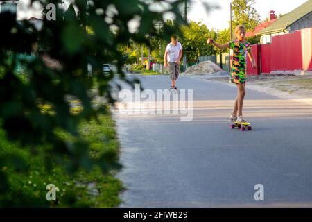 Redéfinit les enfants heureux jouant sur le skateboard dans la rue. Les enfants de race blanche à la planche de Penny, à la pratique du skateboard. Concept d'enfance et d'amitié Banque D'Images