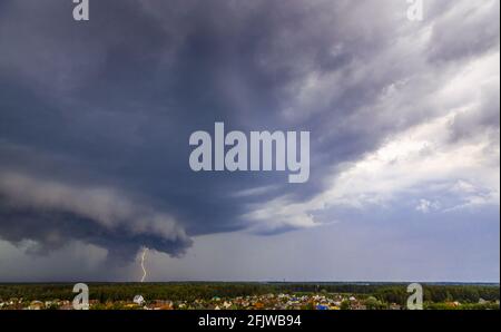 Un violent orage avec un ouragan et des éclairs clignotants a balayé le village. Nuages sombres, pluie et vent fort. Banque D'Images