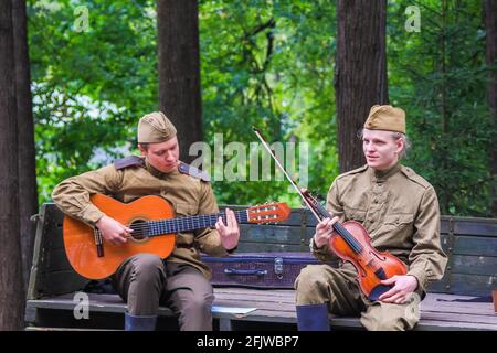 Reconstruction du temps de la Grande guerre patriotique. Les soldats dans la voiture jouent le violon et la guitare à côté du garçon. Moscou Russie septembre 16 Banque D'Images