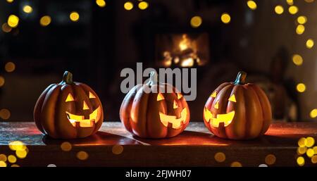 Citrouilles sculptées illuminées pour Halloween sur une table en bois. Arrière-plan de vacances. Banque D'Images