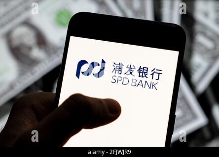 Sur cette photo, le logo SPD de la Shanghai Pudong Development Bank est affiché sur un smartphone avec une devise USD (dollar des États-Unis) en arrière-plan. Banque D'Images