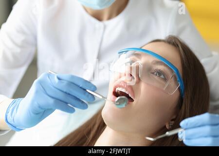 Le dentiste examine la cavité buccale de la femme dans le bureau de près Banque D'Images