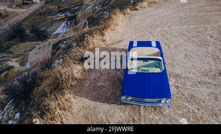 Cappadoce, Turquie. Voiture rétro bleue américaine dans le désert pendant le coucher du soleil. Photo de haute qualité Banque D'Images