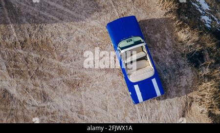 Cappadoce, Turquie. Voiture rétro bleue américaine dans le désert pendant le coucher du soleil. Photo de haute qualité Banque D'Images