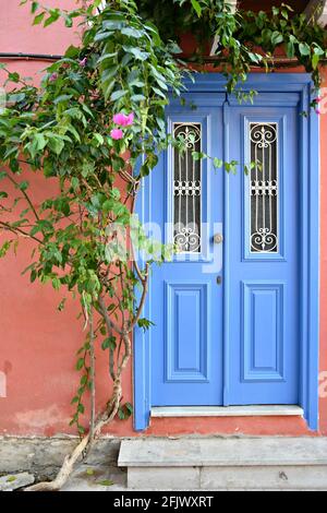 Façade de maison néoclassique avec porte en bois bleu clair avec grilles en fer sur un mur en stuc vénitien à Nafplio, Argolis Péloponnèse, Grèce. Banque D'Images