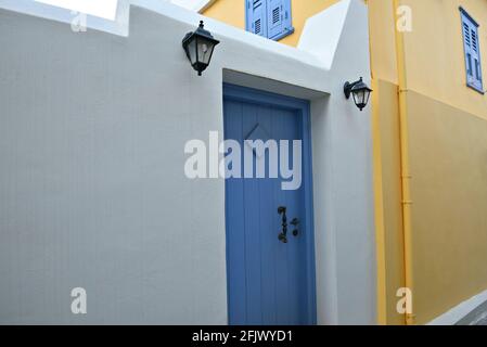 Façade de maison néoclassique avec un mur blanc et ocre, porte en bois bleu clair et lanternes murales en fonte dans la vieille ville de Nafplio, Argolis Péloponnese, GR. Banque D'Images