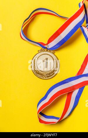 Tout simplement plat de la mise en forme gagnant ou champion de la médaille d'or isolé sur fond jaune coloré. Victoire première place de la compétition. Gagnant ou Banque D'Images