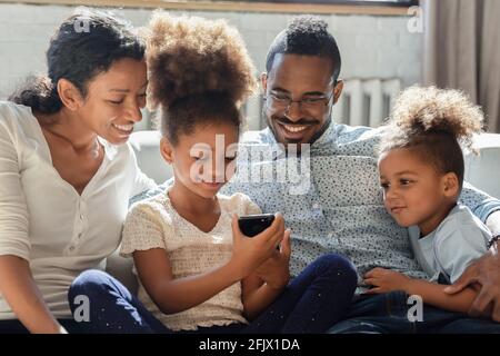 Papa heureux et les enfants qui s'amusent à regarder des contenus incroyables Banque D'Images