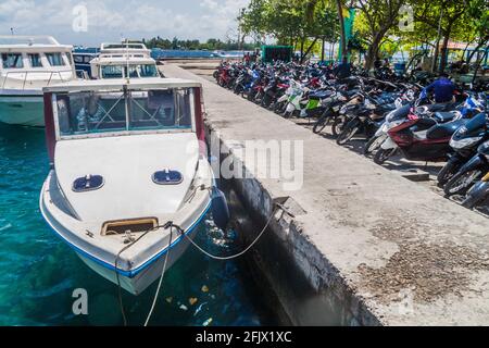 MASCULIN, MALDIVES - 11 JUILLET 2016: Bateaux ancrés à côté du parking de motos à Malé. Banque D'Images