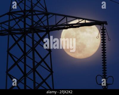 Iwade, Kent, Royaume-Uni. 26 avril 2021. Une pleine lune rose « électrisante » vue derrière un pylône d'électricité à Iwade, dans le Kent. Crédit : James Bell/Alay Live News Banque D'Images