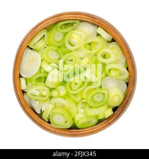 Tranches de échalotes fraîches, dans un bol en bois. Des bulbes hachés d'oignons verts, également des oignons de printemps ou des sibies. Légume au goût d'oignon doux. Gros plan. Banque D'Images