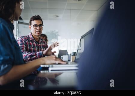 Jeune homme d'affaires discutant de nouvelles stratégies avec des collègues en réunion. équipe d'affaires ayant une réunion dans la salle de réunion du bureau. Banque D'Images