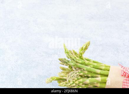 Bouquet d'asperges en papier brun sur fond gris, format horizontal Banque D'Images