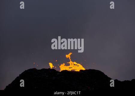 Volcan en éruption sur fond de ciel sombre Banque D'Images