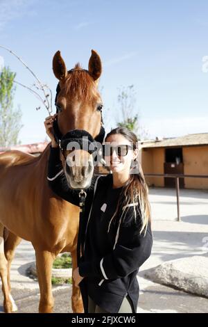 femelle de course de chevaux jockey avec son cheval embrassant, caressant et s'occupant de lui Banque D'Images