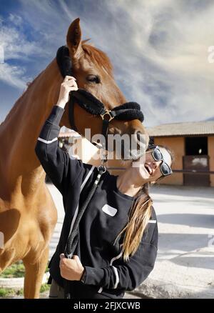 femelle de course de chevaux jockey avec son cheval embrassant, caressant et s'occupant de lui Banque D'Images