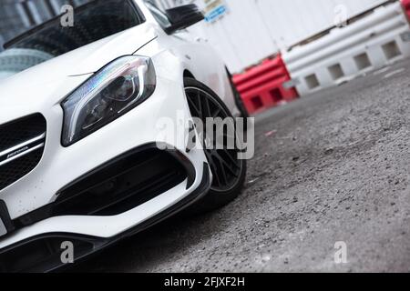 Le phare avant à DEL portant la marque AMG sur UNE Mercedes Benz A45 AMG 2017 Cirrus White avec Aero Pack et roues en alliage noir brillant. Banque D'Images