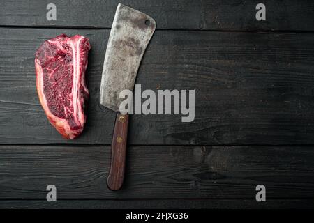 Set de steak de club vieilli sec, sur fond de table en bois noir, plan de dessus avec vue sur le dessus, avec espace pour le texte Banque D'Images